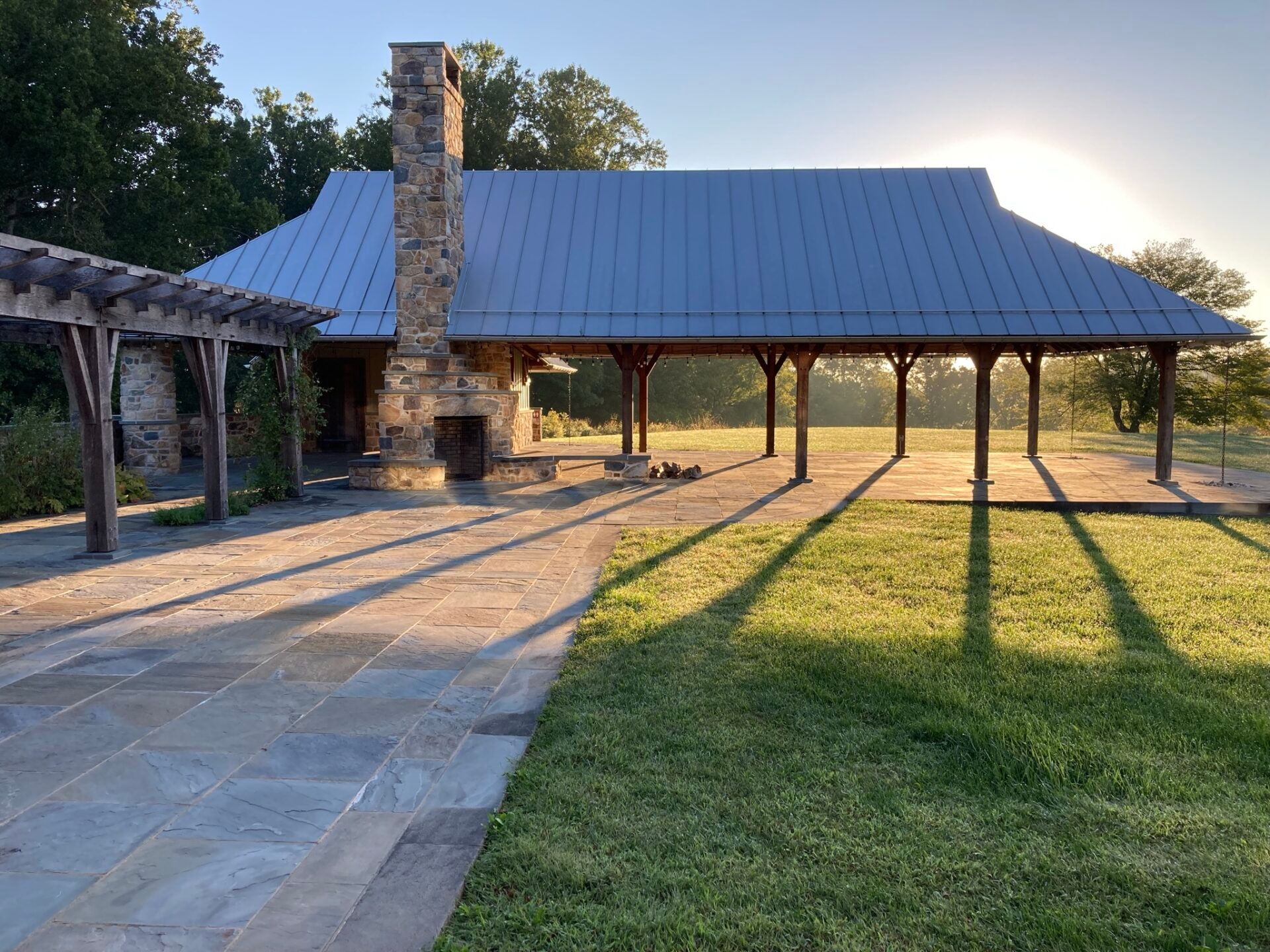 Photo by Sean Quinn
 - The sun shining behind the pavilion and arbor at the Lenfest Center at ChesLen Preserve in late summer.
