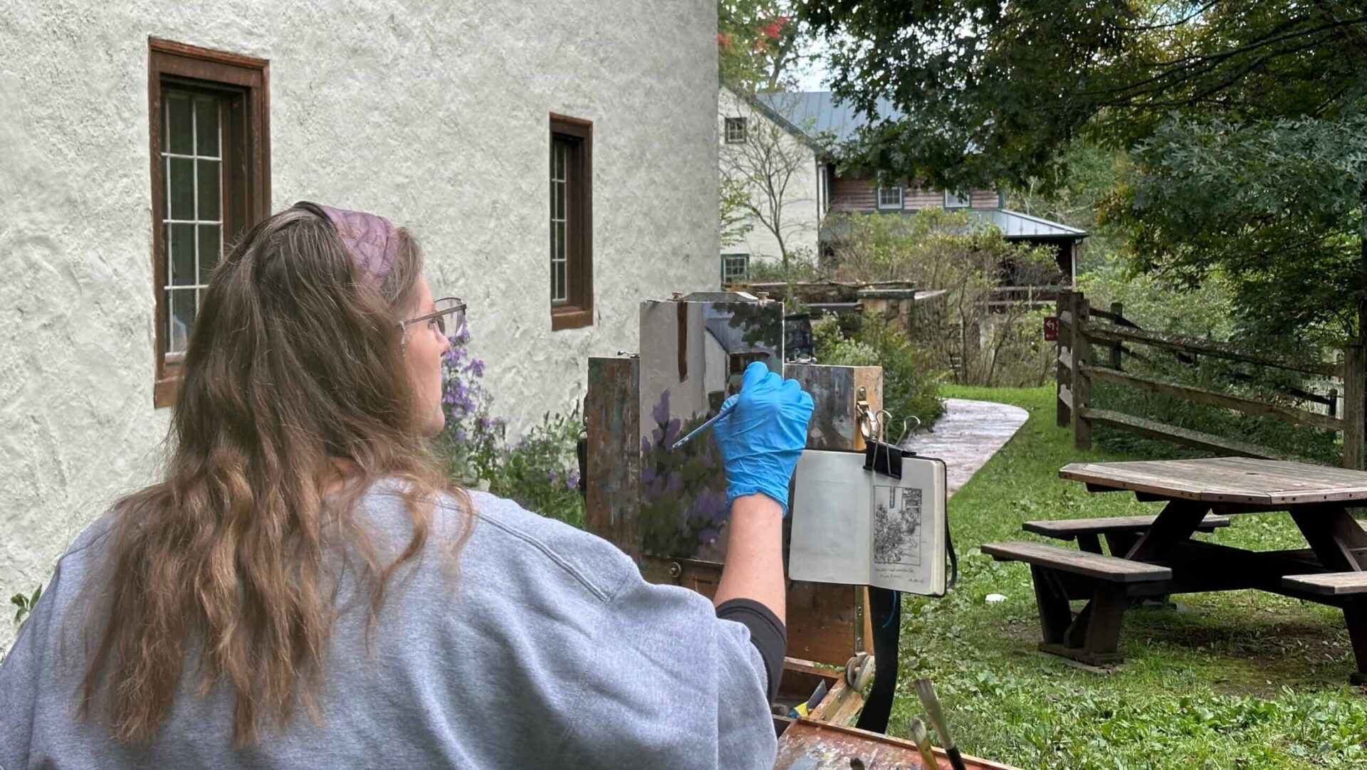 A woman painting a landscape.