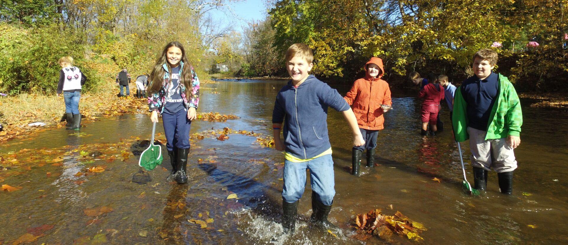 children wading in a stream