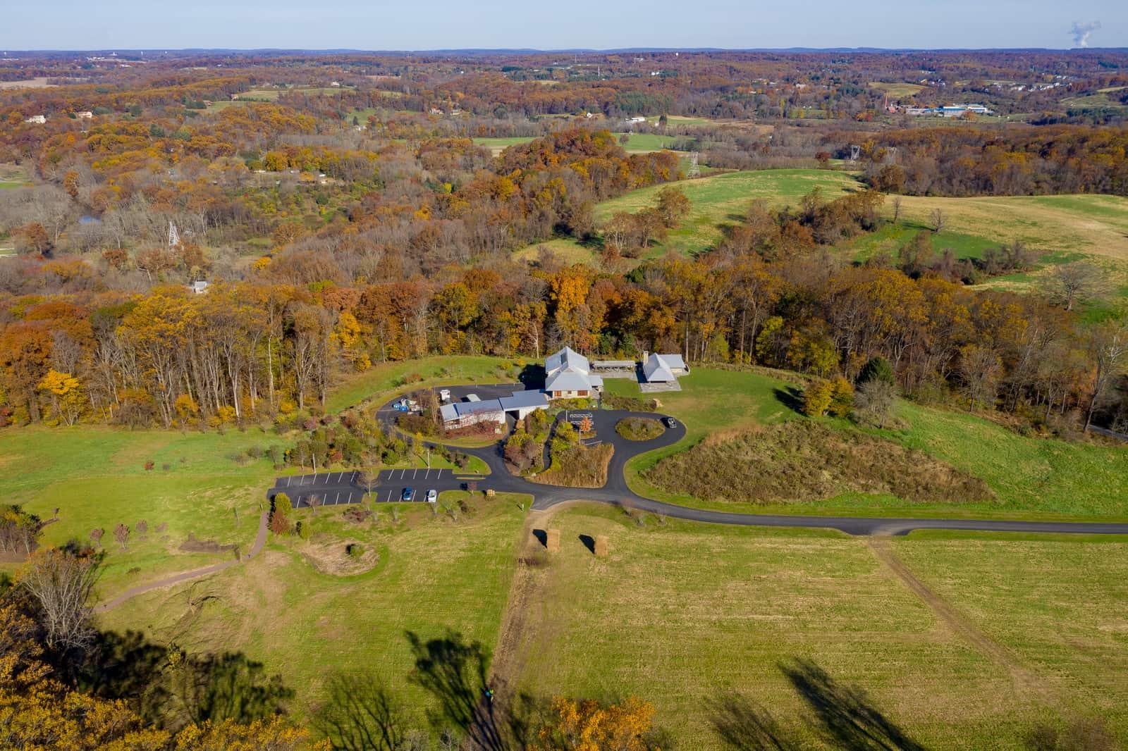 Drone photo of a rambling building set in an expanse of greenery and forest