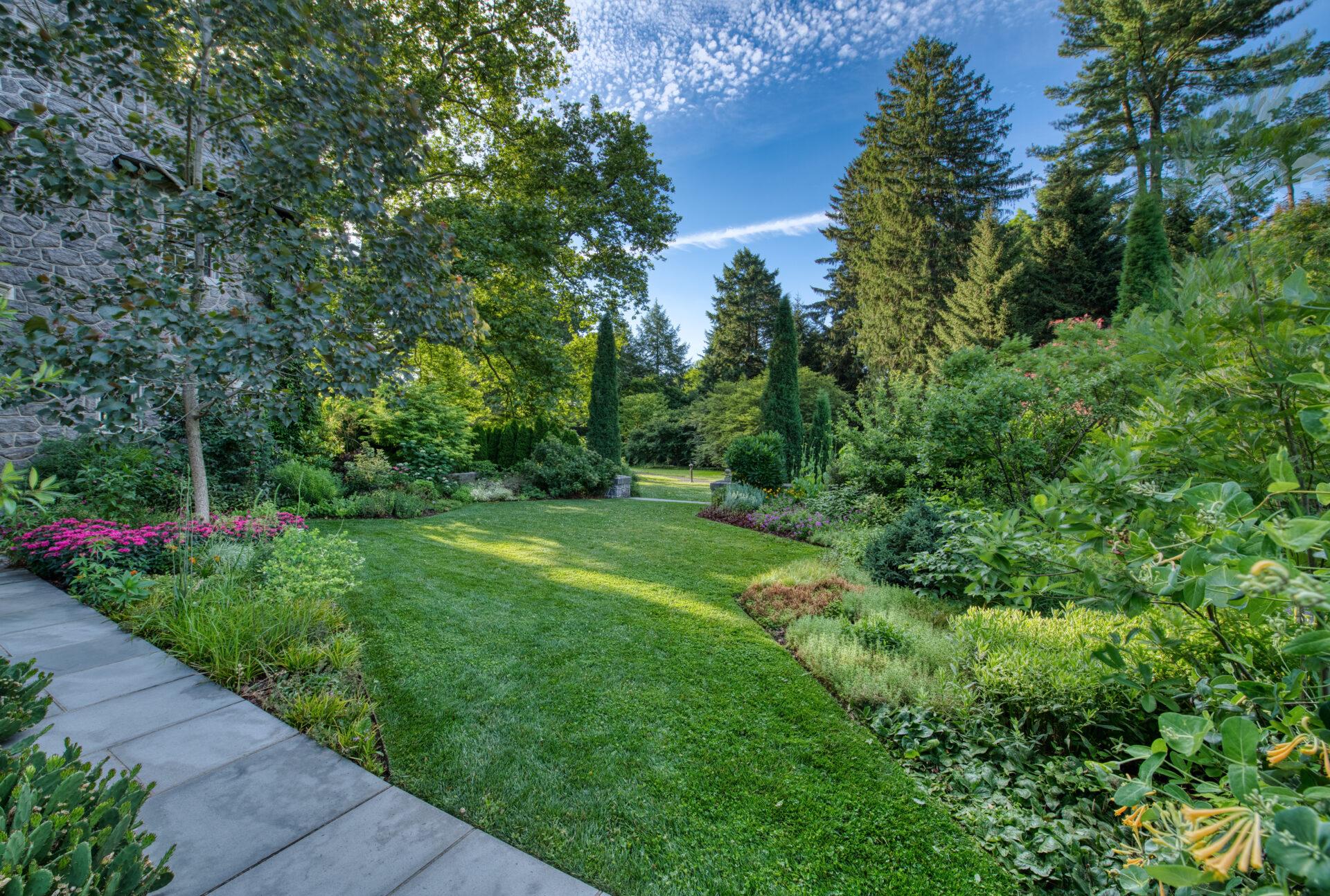 a green, geometrically-shaped lawn bordered by lush plantings