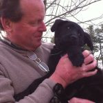 Profile photo of Jack Stefferud holding a black puppy.
