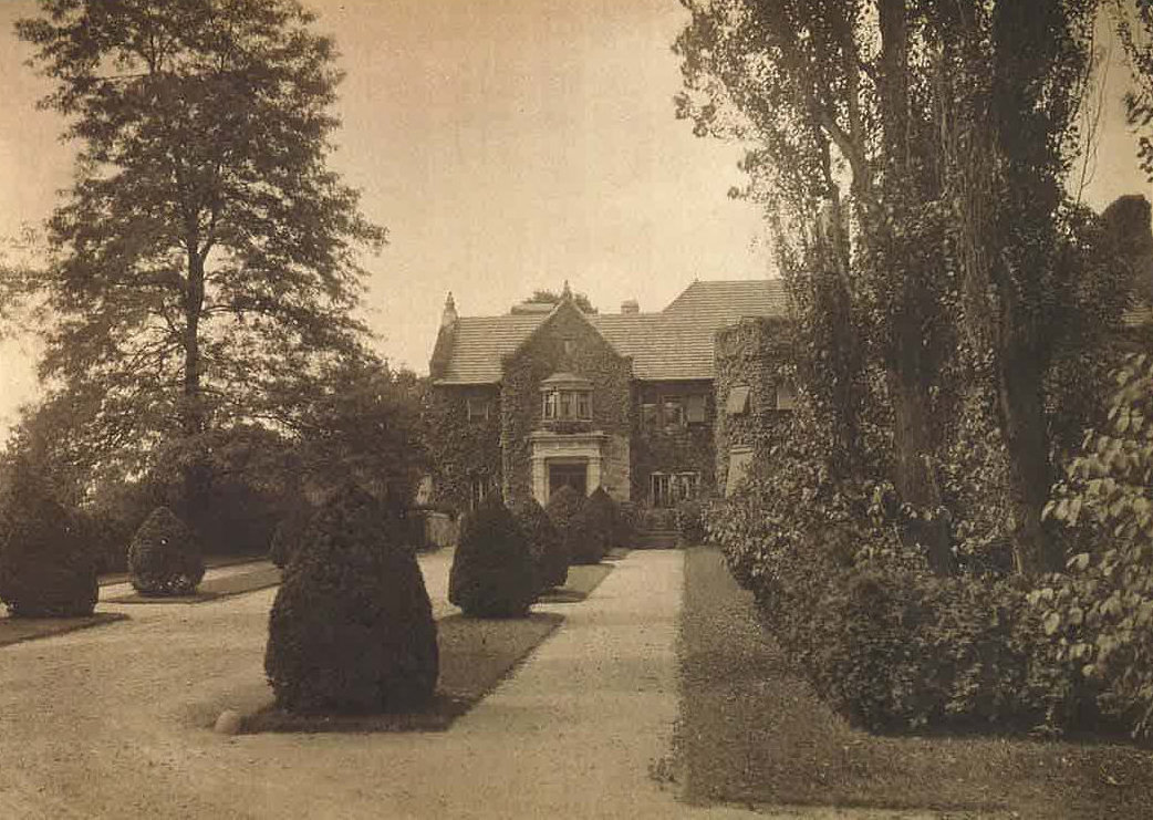 A historic photo of a large stone house.