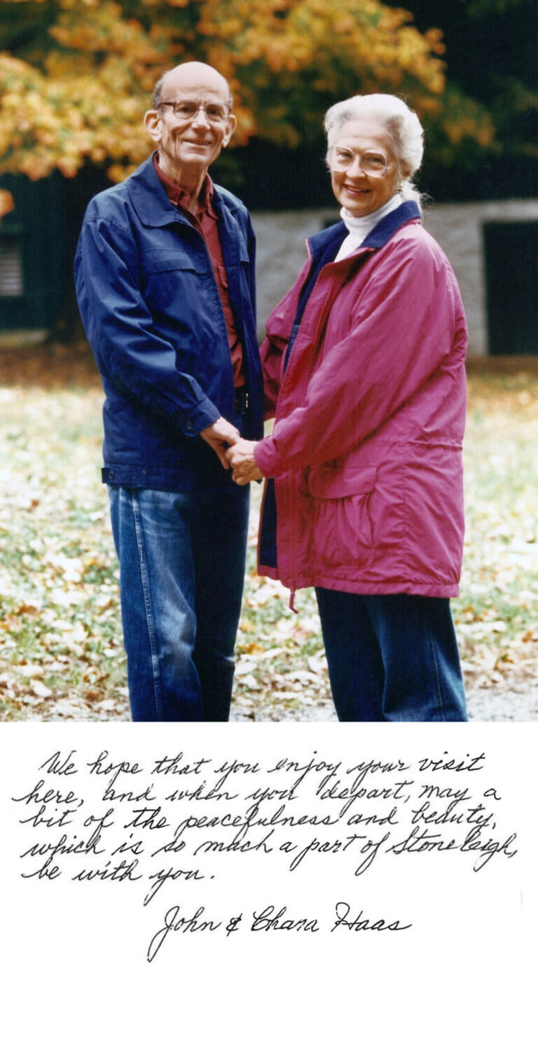 Two people hold hands wearing autumn clothing outdoors