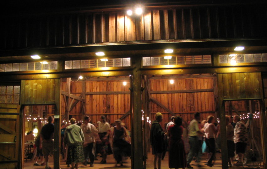 People dancing in a barn at night.