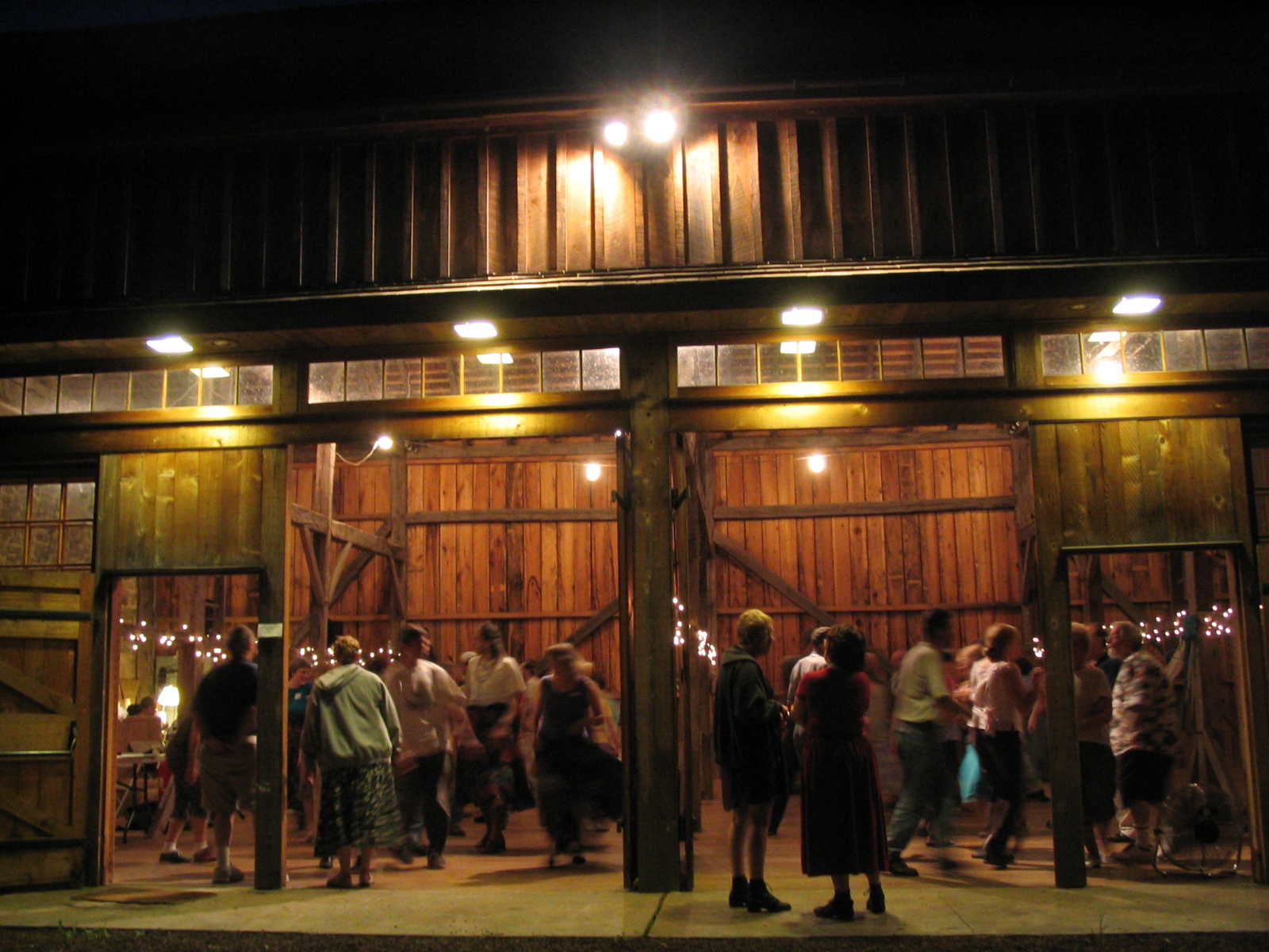People dancing in a barn at night.