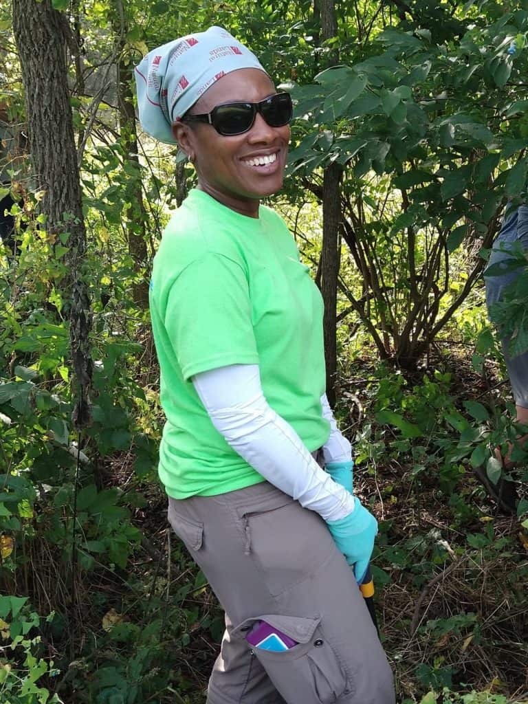 woman volunteer holding loppers in woods