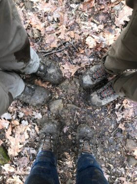 Looking down on muddy boots.