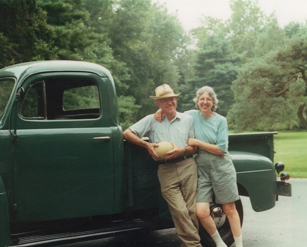 Portrait of Bob & Betsy Hawkes outdoors in front of a truck.