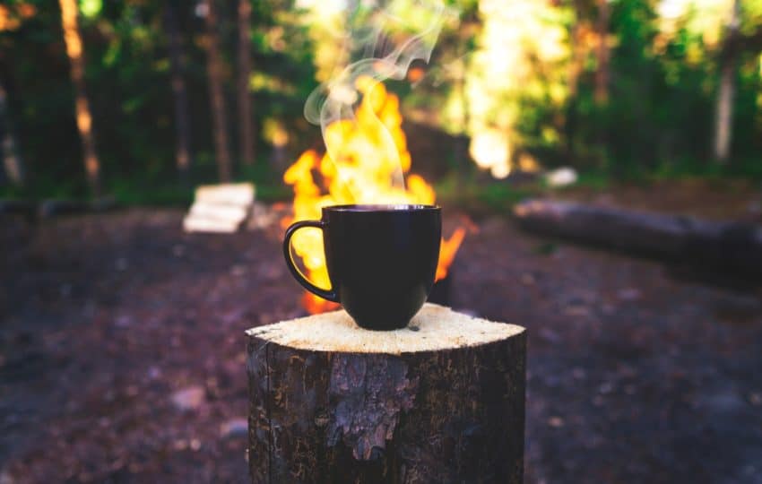 black ceramic mug on brown wooden log