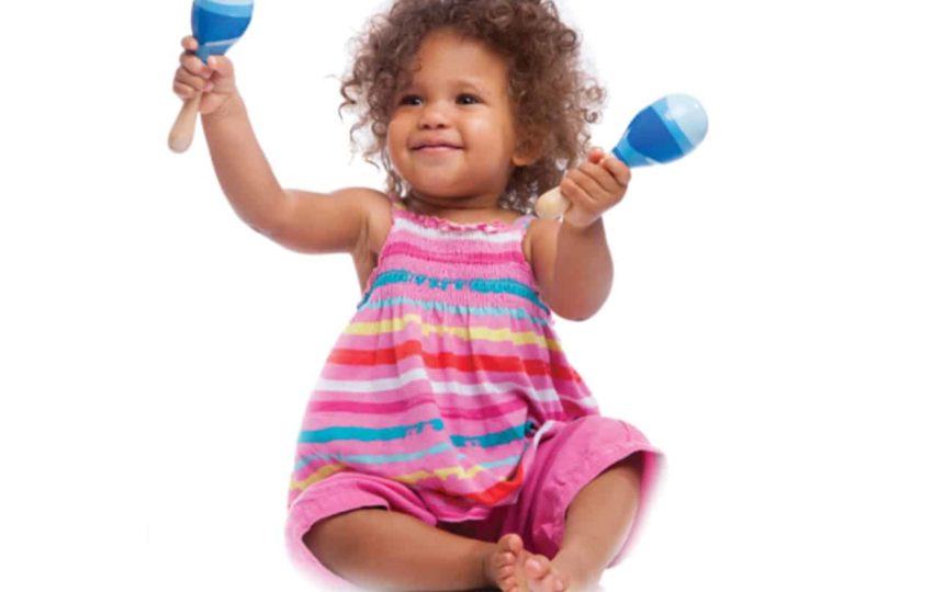 Child sitting and playing with maracas