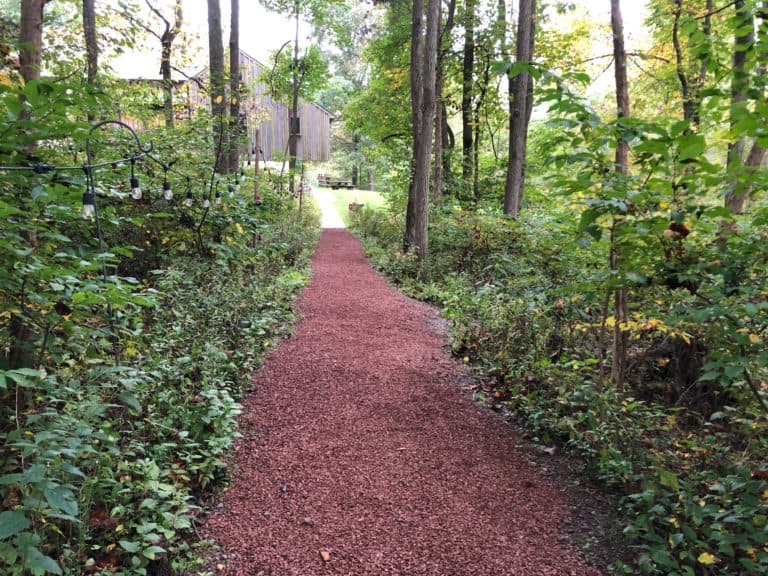 Fresh red gravel spread on trail through woods