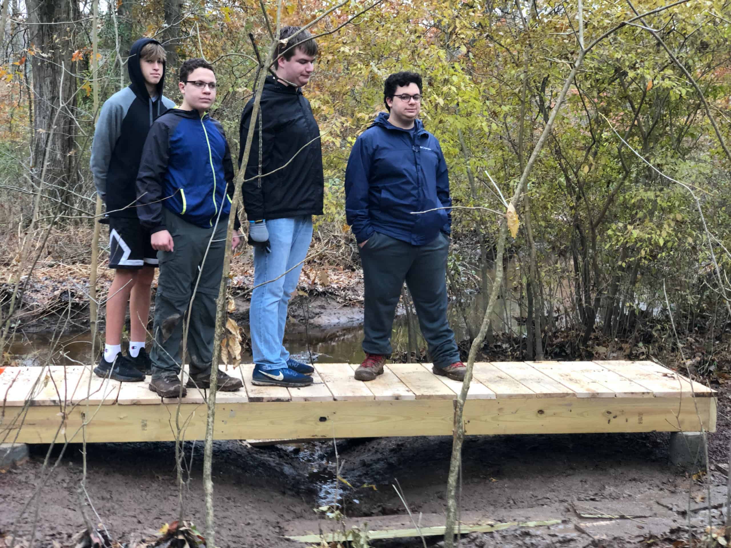 Boy Scouts standing on a footbridge they just built