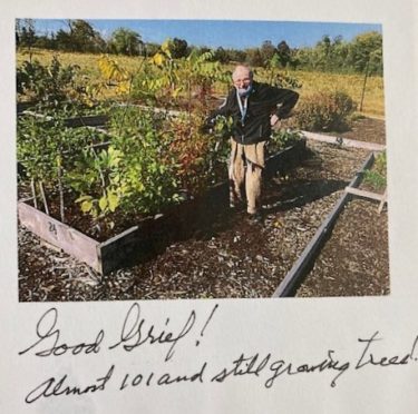 Photo of Paul Felton at 101 standing next to his garden. 