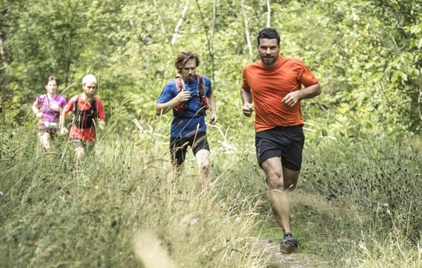 Group of trail runners trainning on a local trail in the summer.