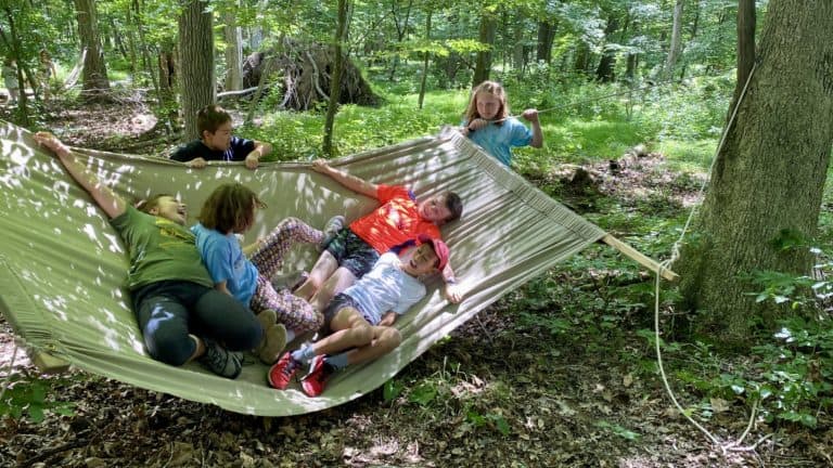 Kids playing on a hammock at summer camp