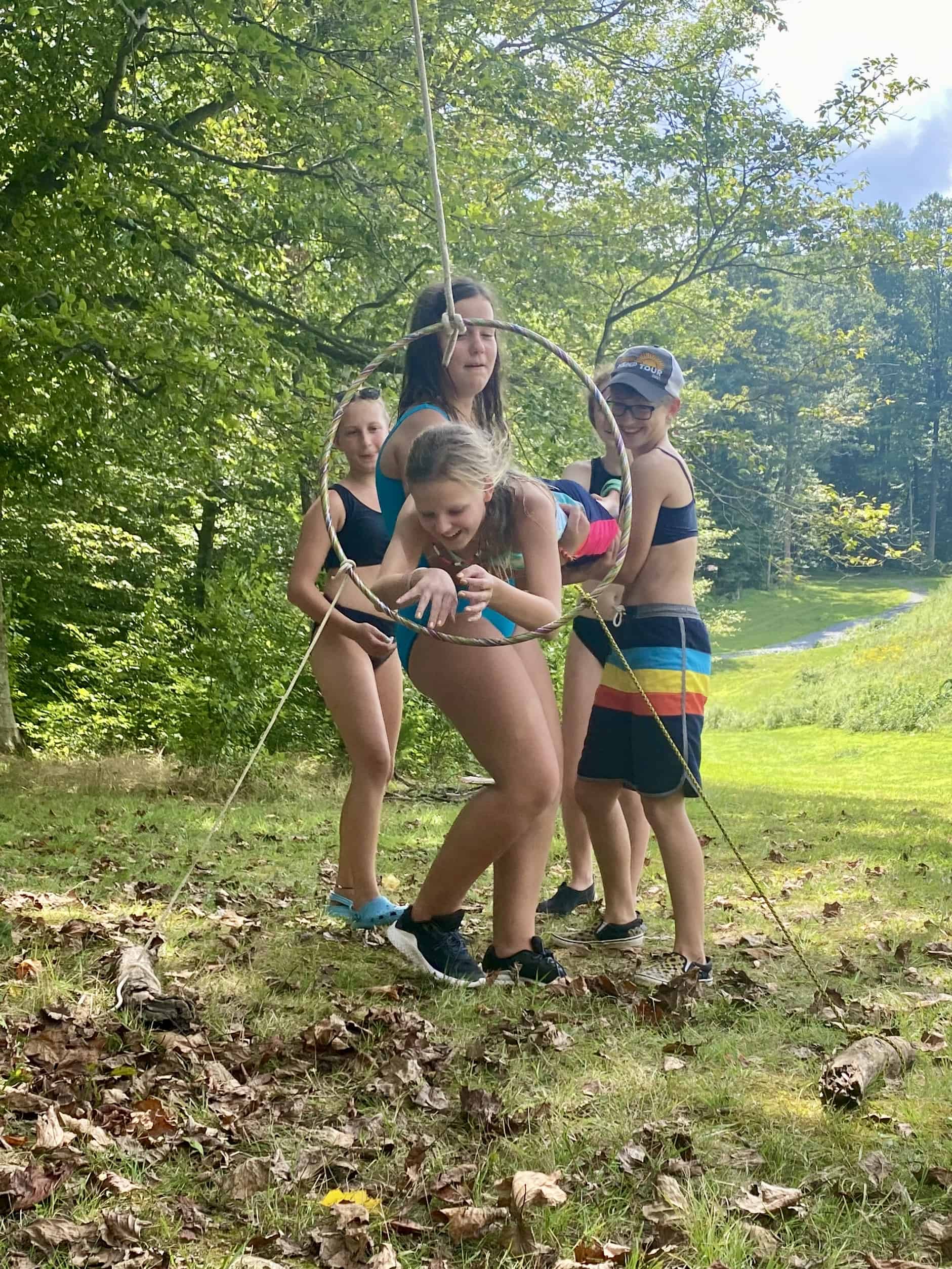 Campers playing a game with a hula hoop