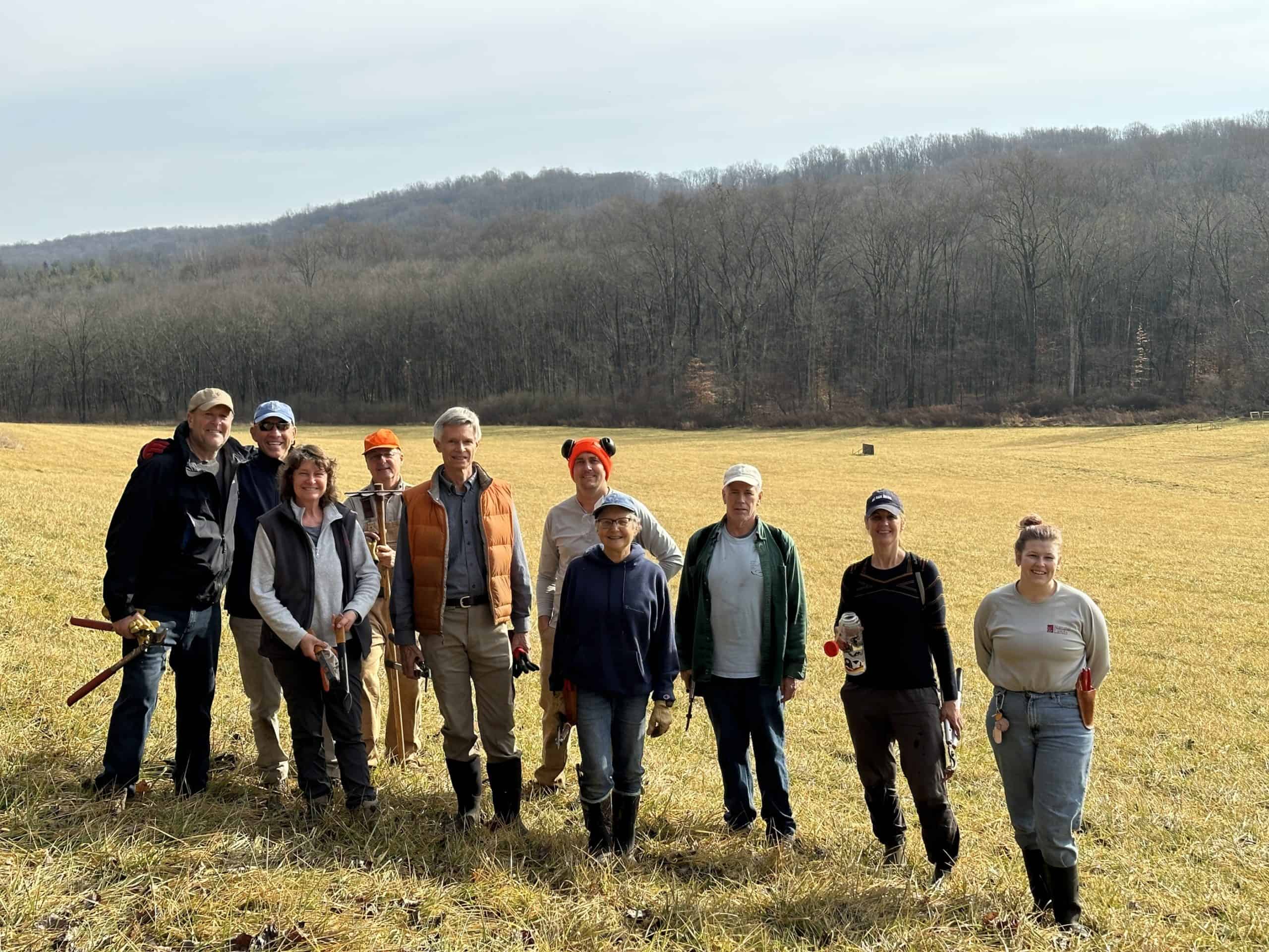 A group of volunteers posing in a field at Crow's Nest Preserve.