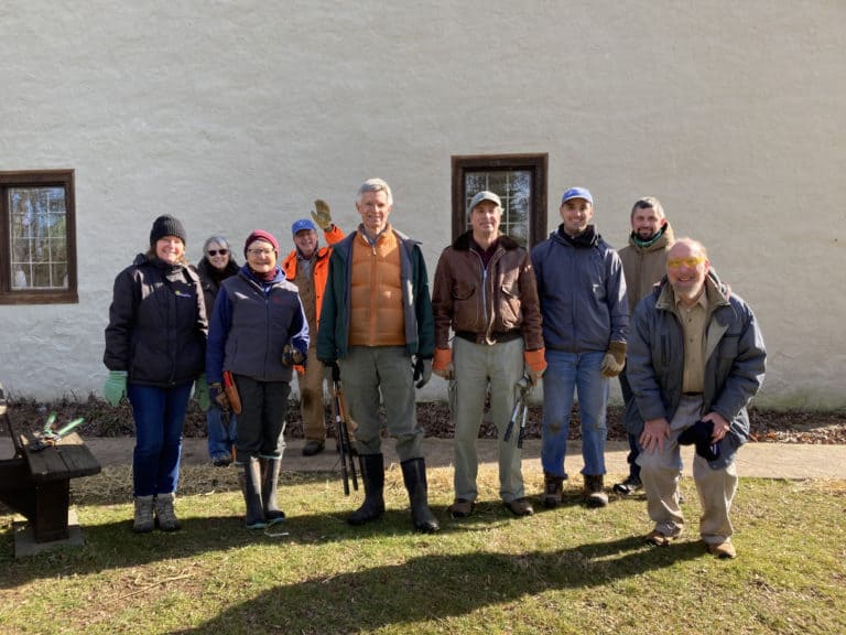 A group of volunteers posing outside the barn at Crow's Nest Preserve