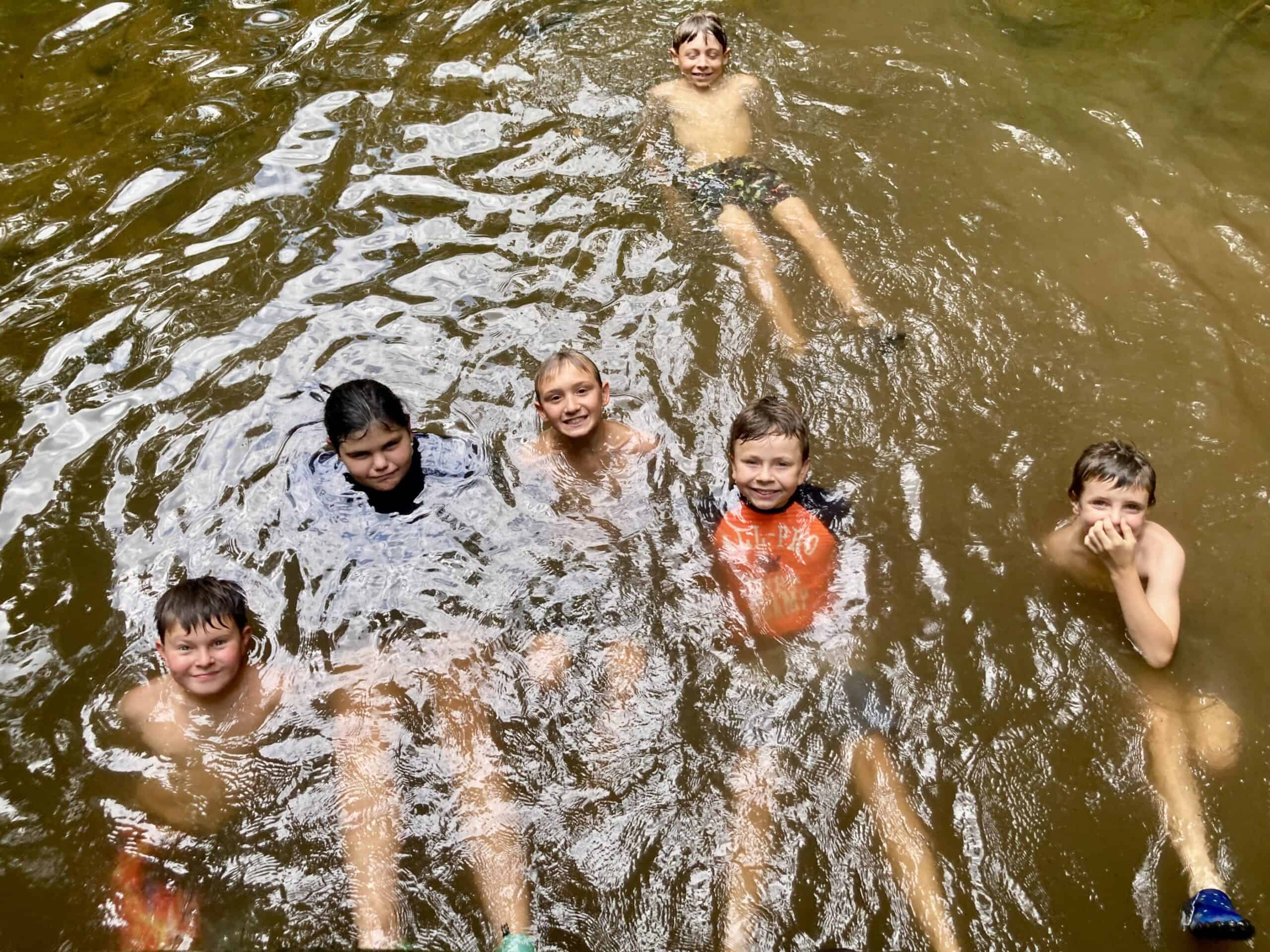 Kids swimming in a stream