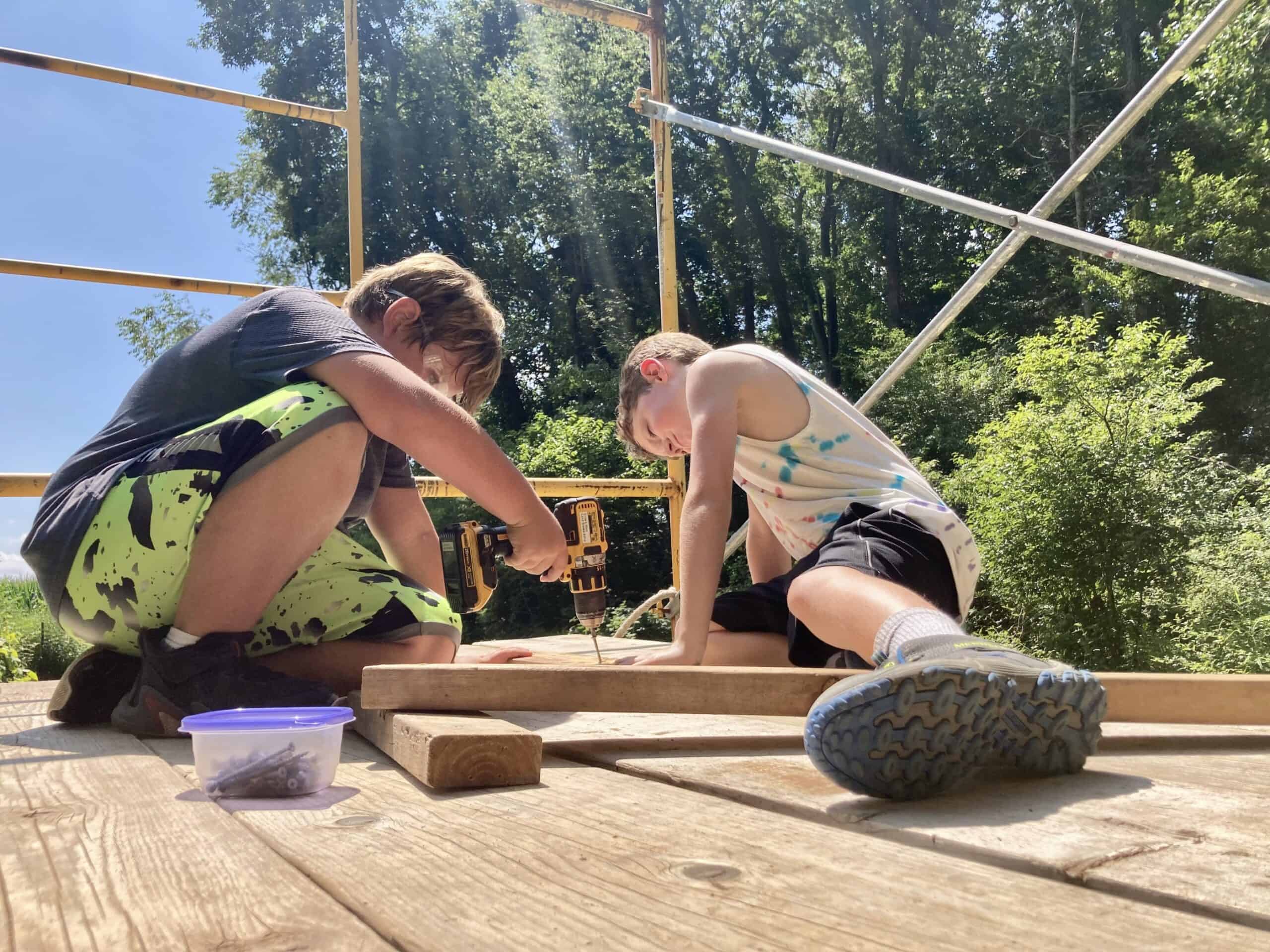 Campers putting together a project with screws at Crow's Nest Camp