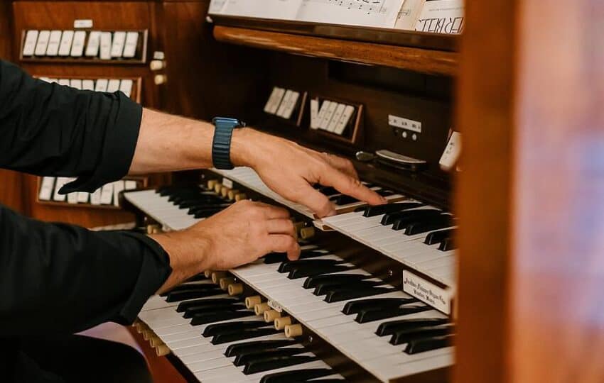hands playing a pipe organ