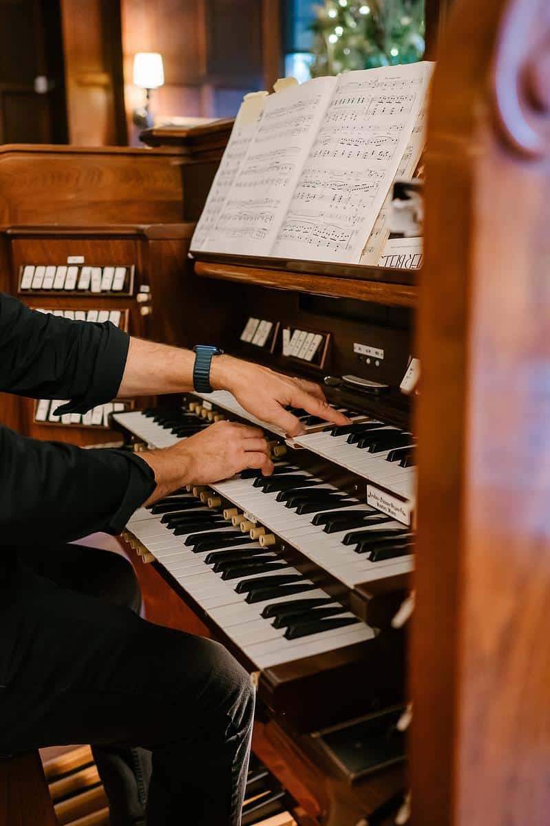 hands playing a pipe organ