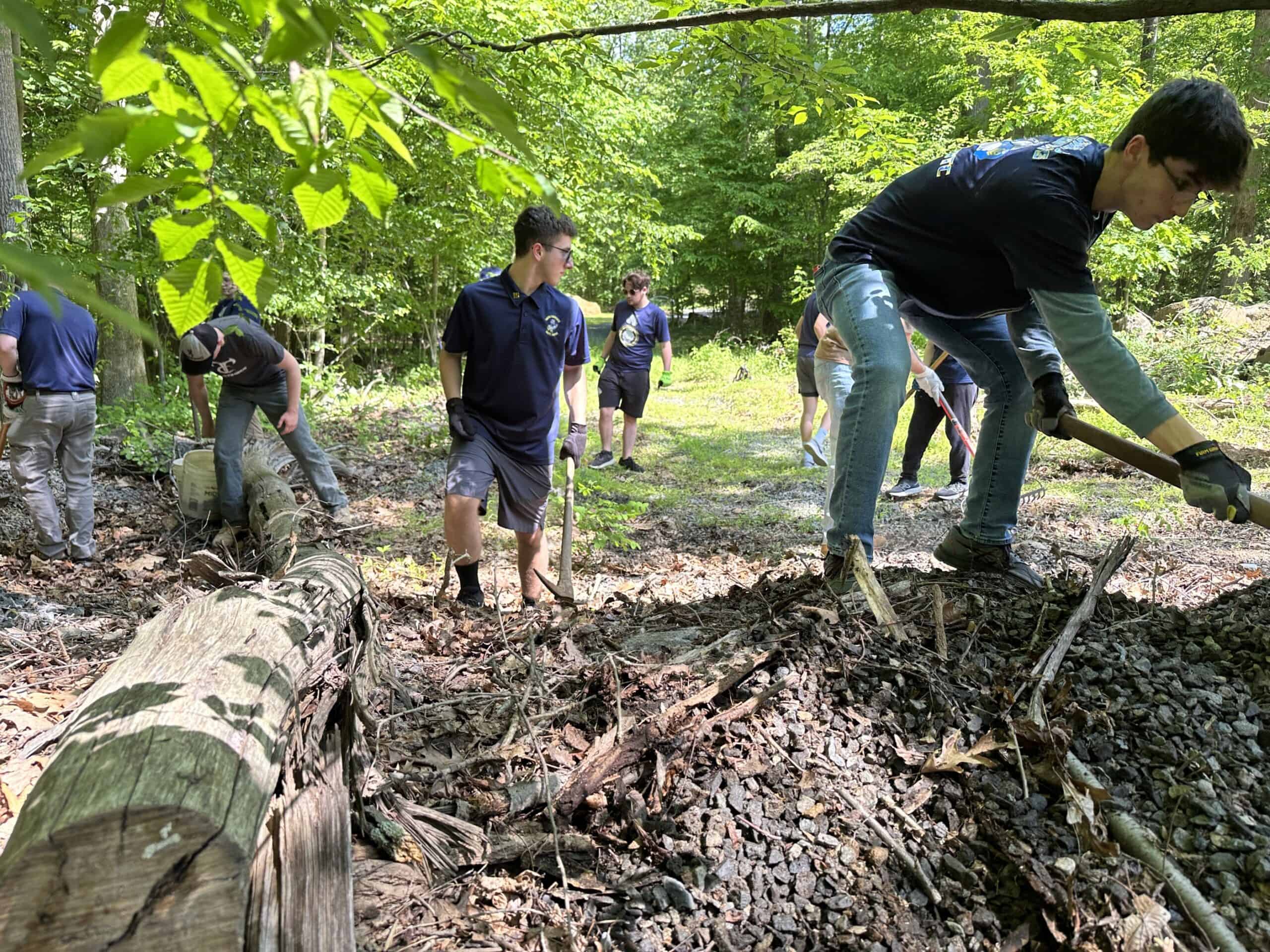 Owen J. Roberts JROTC students with rakes and shovels moving gravel at Crow's Nest's Warwick Woods