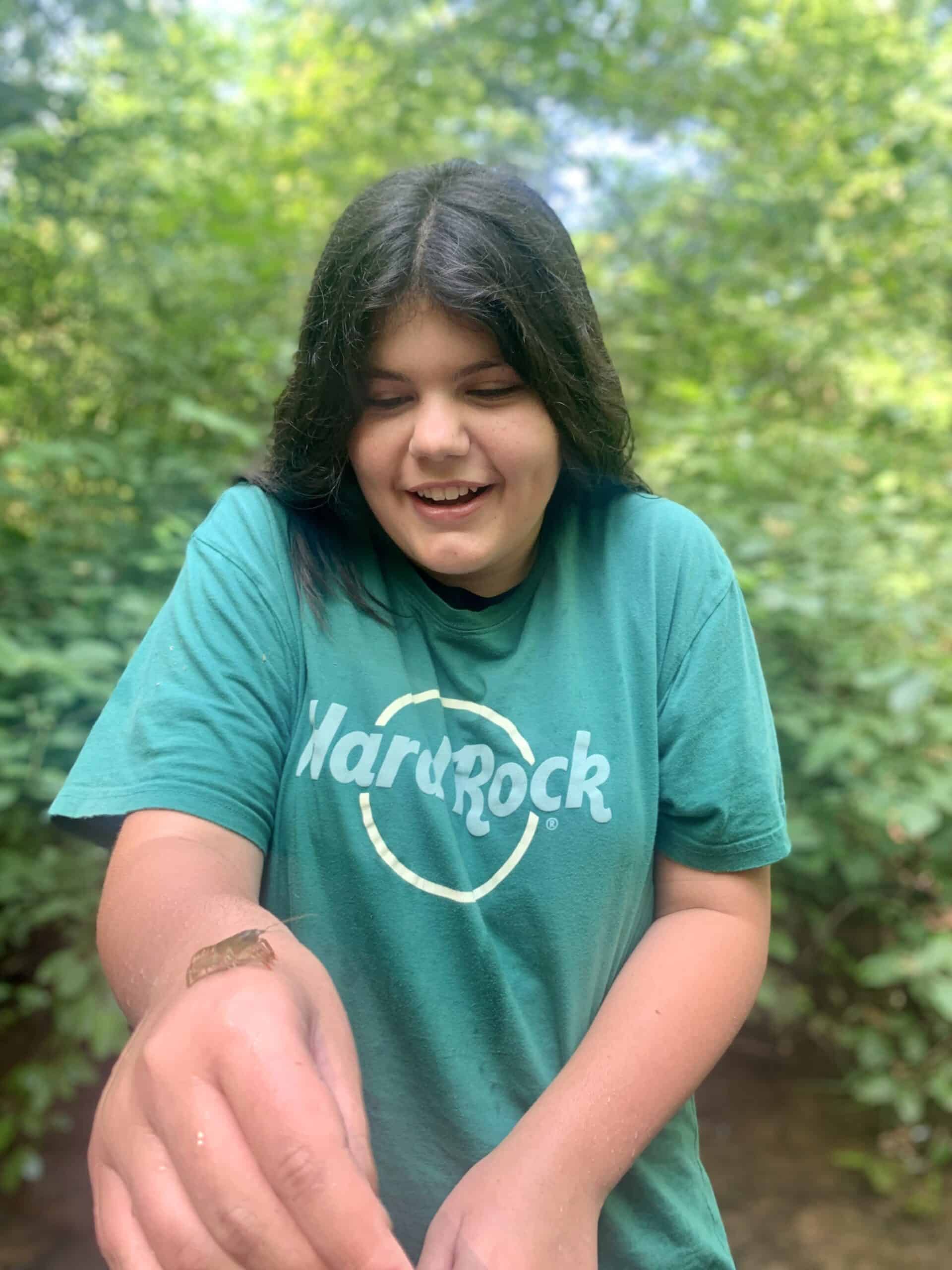 Summer camper holding a crayfish