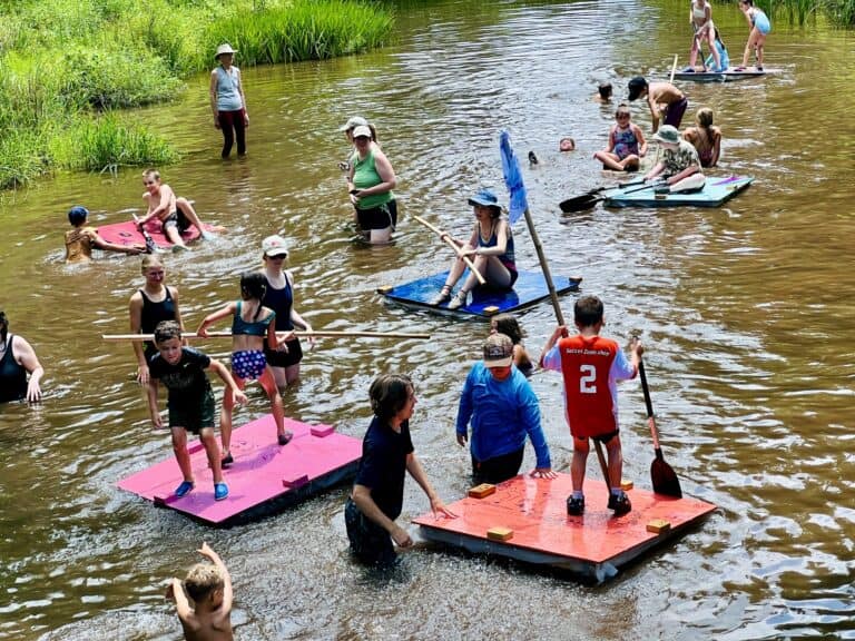Summer campers trying out homemade rafts on French Creek