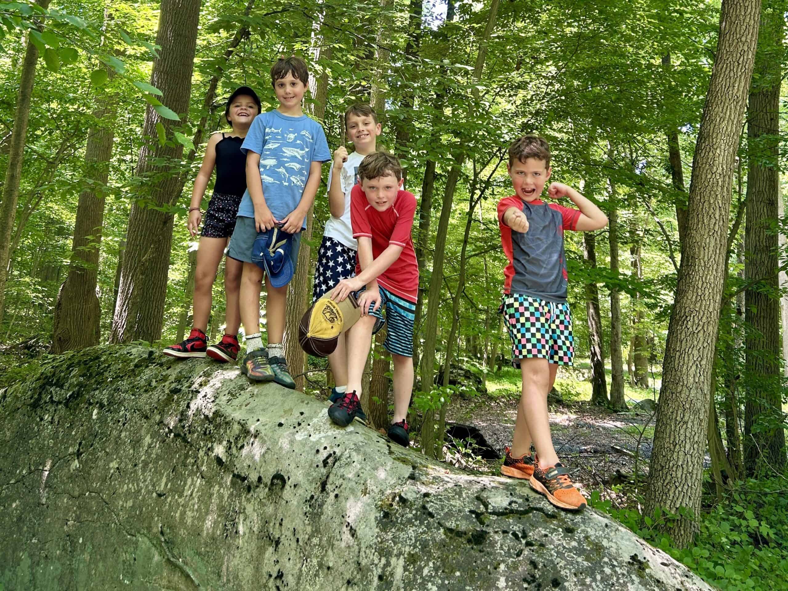 Camp kids posing on a boulder at Crow's Nest Preserve.