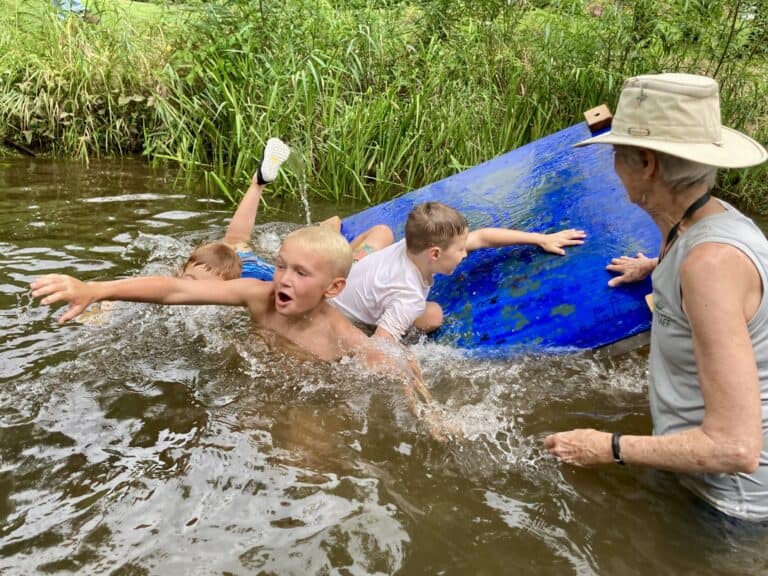 Kids at Crow's Nest camp playing on rafts in the creek