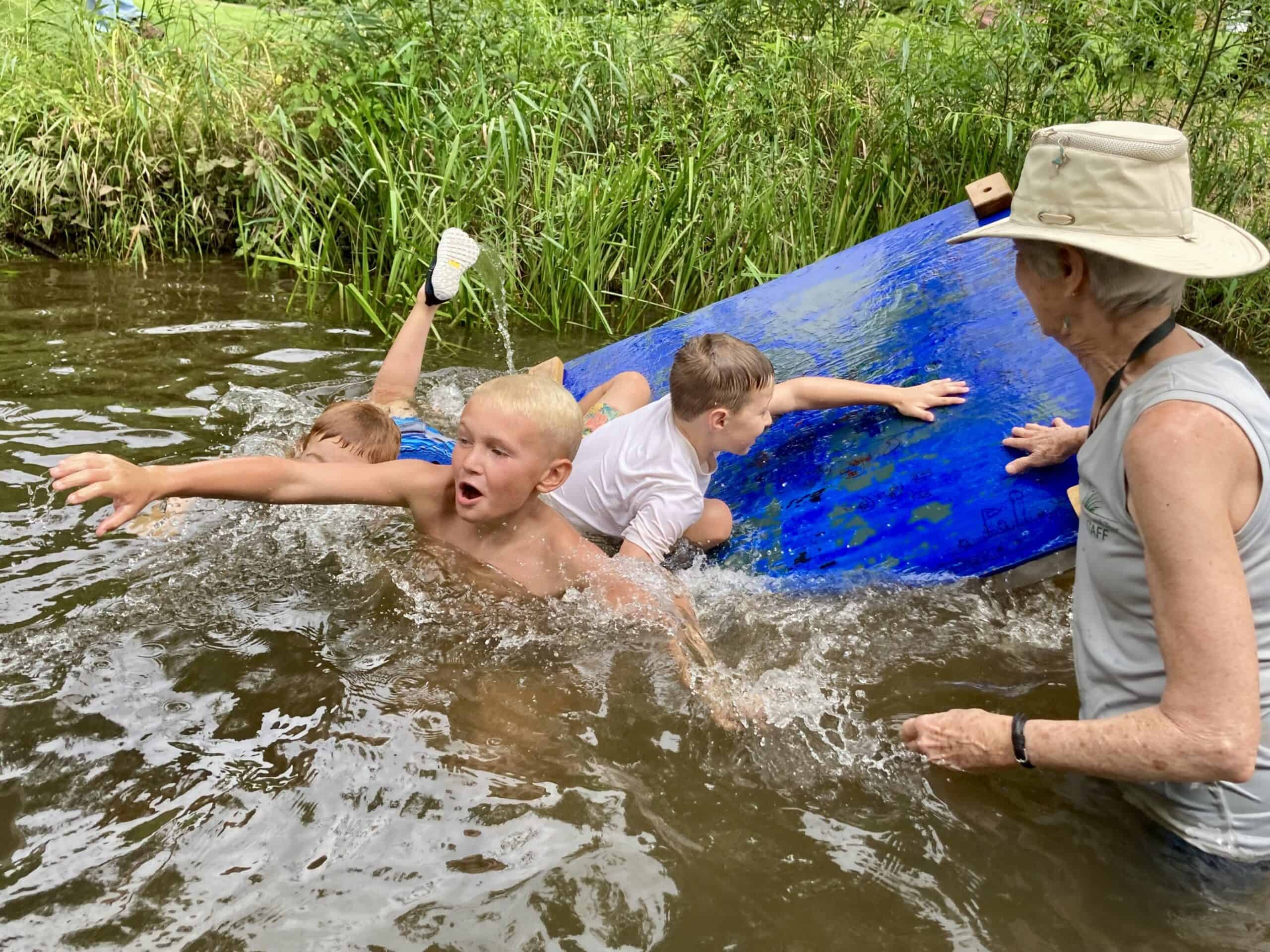 Kids at Crow's Nest camp playing on rafts in the creek