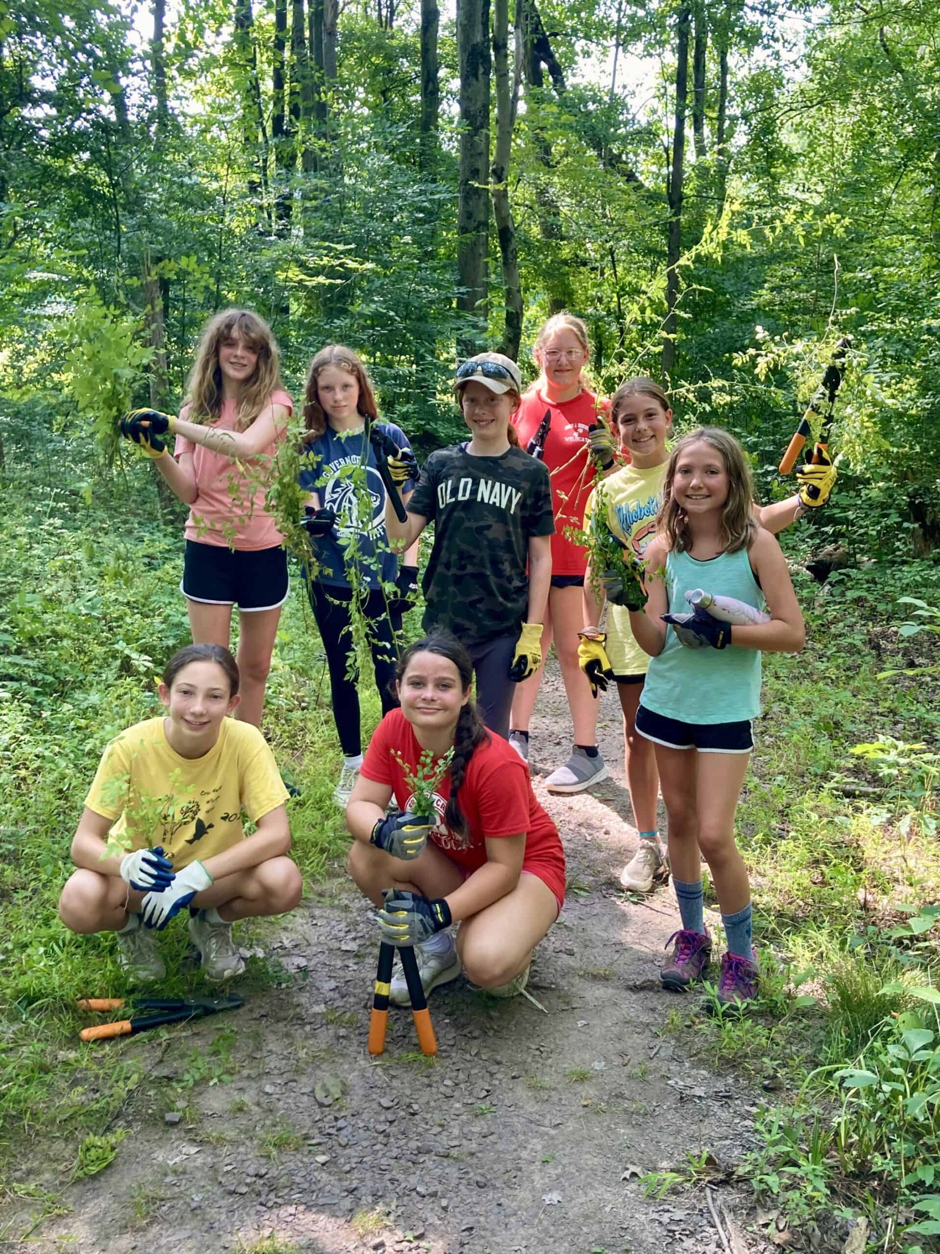 Crow's Nest Camp kids posing with tools during a day of service