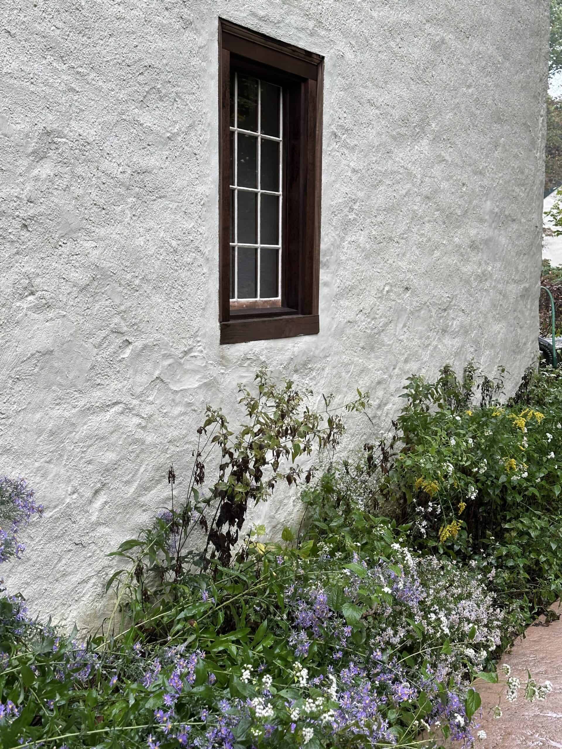 Wooden window in a stucco stone wall.