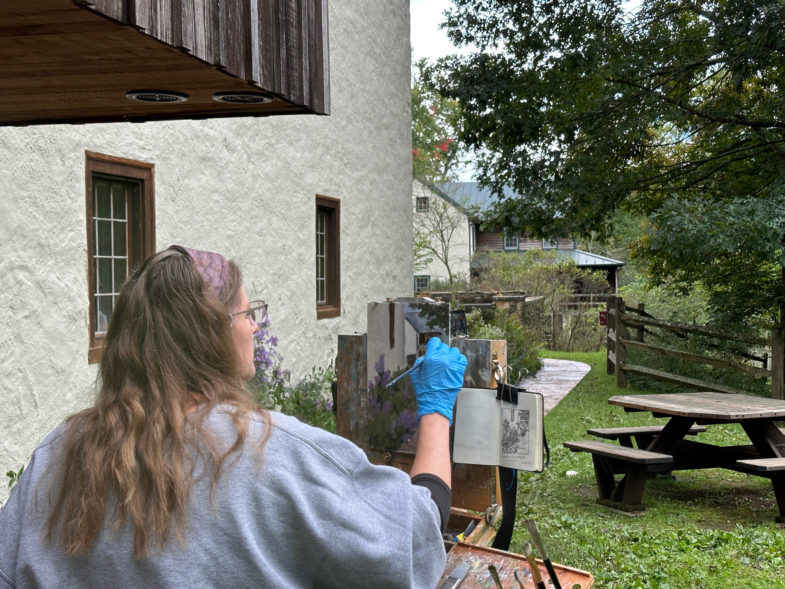 A woman painting a landscape.