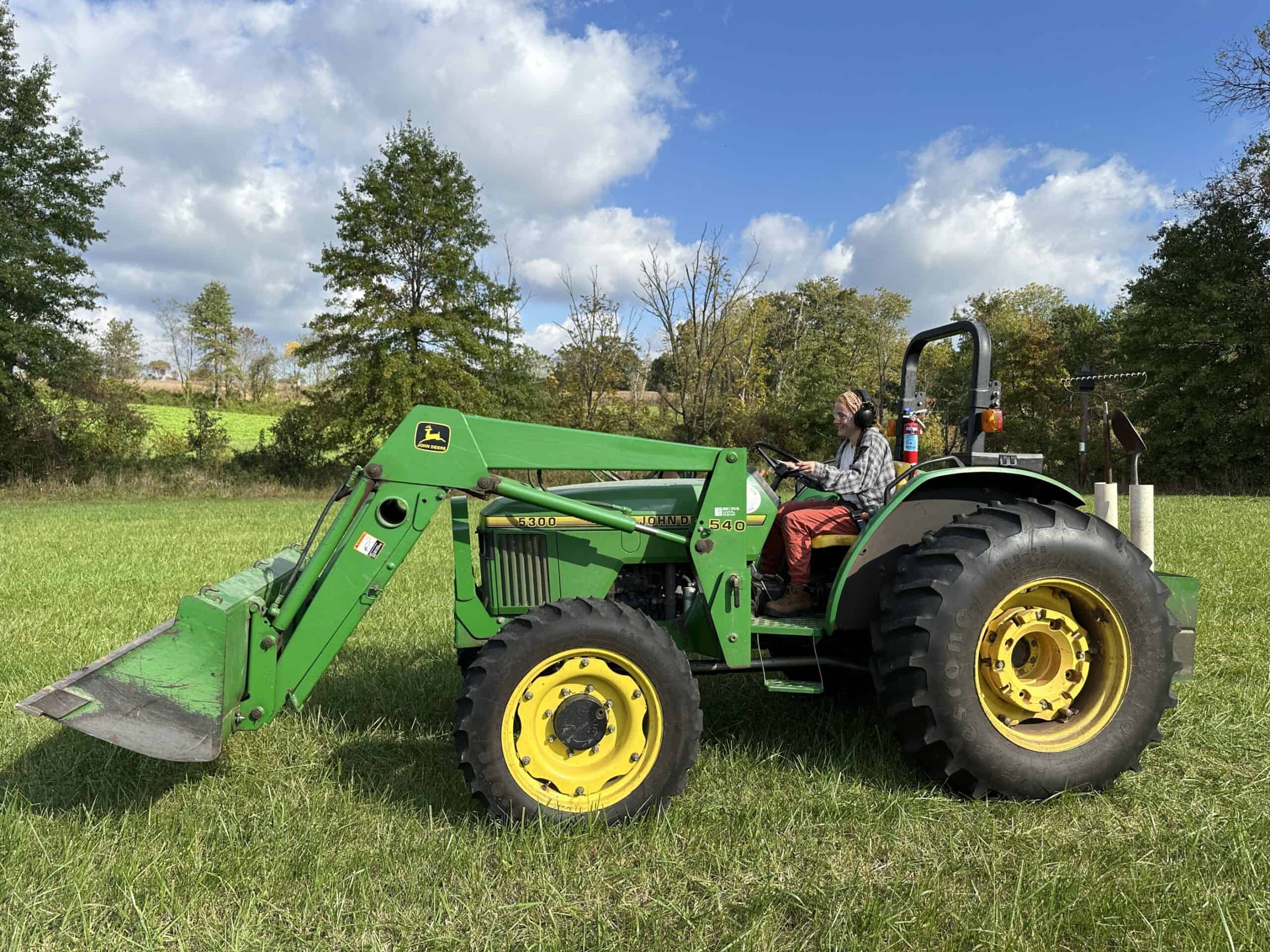 A woman driving a tractor.