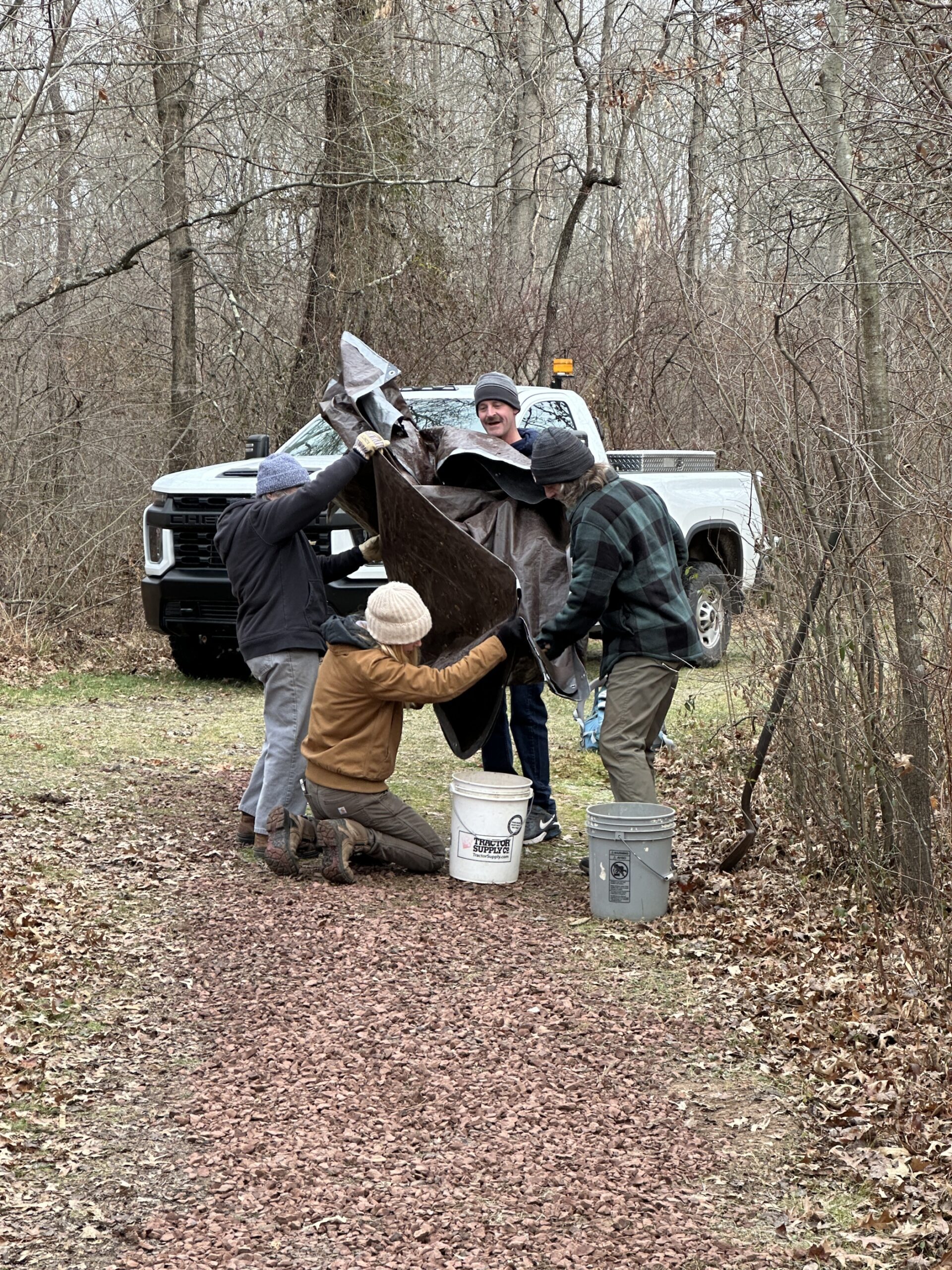 Volunteers pouring gravel into buckets.