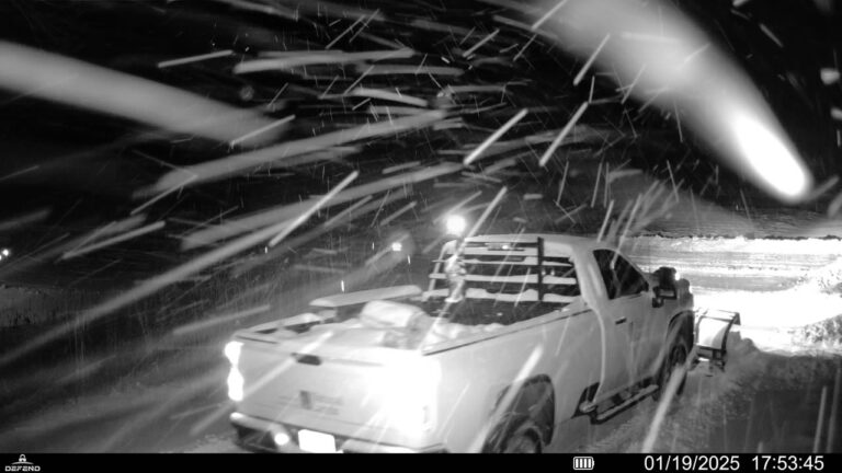 Snowplow truck operating in driving snow at night